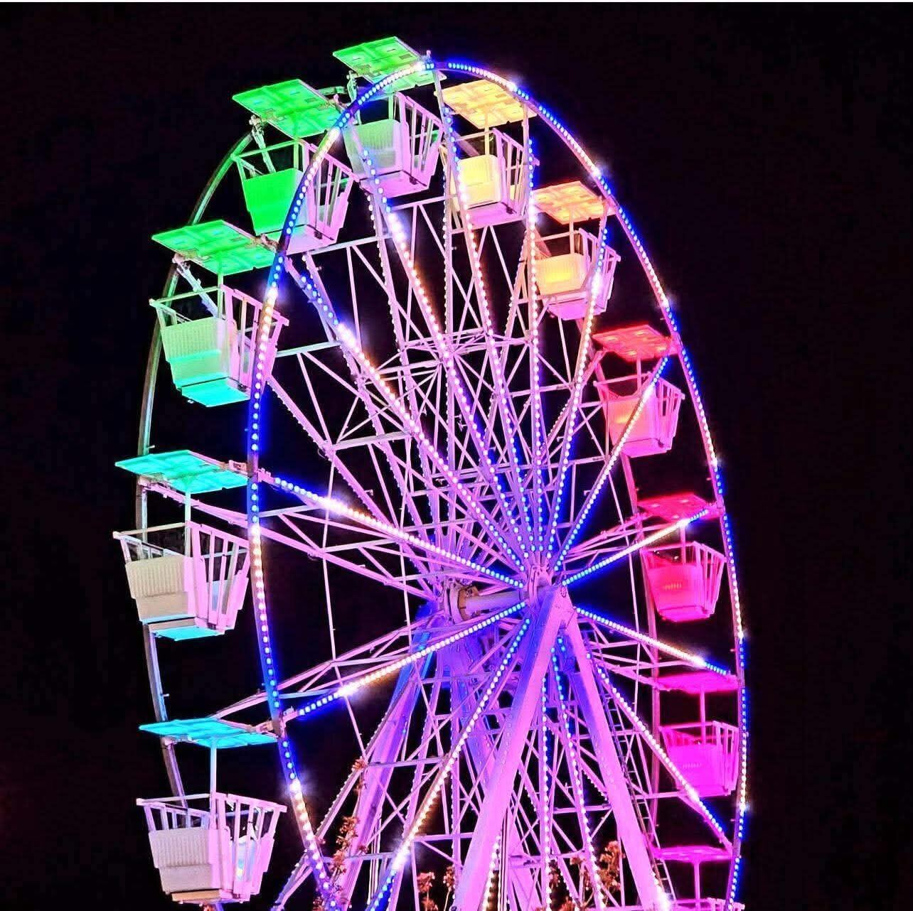 La grande roue Panorama 22 illuminée de nuit par son éclairage FunLED multicolore
